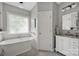 Bathroom featuring a soaking tub, wainscoting, stylish fixtures, and natural light at 104 Edgewater Park St, Davidson, NC 28036
