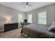 Cozy bedroom featuring neutral colors, a ceiling fan, and a dark-colored dresser and desk at 104 Edgewater Park St, Davidson, NC 28036