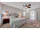 Cozy bedroom featuring a ceiling fan, neutral walls, sitting area, and ensuite bathroom at 104 Edgewater Park St, Davidson, NC 28036