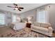Comfortable bedroom with a ceiling fan, neutral walls, sitting area, and large windows at 104 Edgewater Park St, Davidson, NC 28036