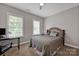 Neutral bedroom with large windows and a comfortable bed featuring a curved headboard at 104 Edgewater Park St, Davidson, NC 28036