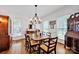 Bright dining room with large windows, hardwood floors, an antique hutch and elegant chandelier at 104 Edgewater Park St, Davidson, NC 28036