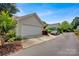 Attached two-car garage with white door and landscaped front yard at 104 Edgewater Park St, Davidson, NC 28036