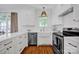 Bright white kitchen with stainless steel appliances, undermount sink, white countertop, and hardwood floors at 104 Edgewater Park St, Davidson, NC 28036