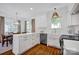 Bright white kitchen with a large island, pendant lighting, stainless steel appliances, and hardwood floors at 104 Edgewater Park St, Davidson, NC 28036