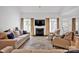Spacious living room featuring a fireplace, large windows, hardwood floors, and neutral-toned furniture at 104 Edgewater Park St, Davidson, NC 28036