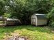 Spacious backyard featuring a storage shed and rustic wooden chicken coop surrounded by mature trees at 10672 Barberville Rd, Fort Mill, SC 29707