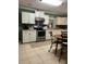 Well-lit kitchen with white cabinets, stainless steel appliances, and tiled floors, offering a functional space at 10672 Barberville Rd, Fort Mill, SC 29707