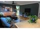 Cozy living room features dark walls, hardwood floors, tan leather sofa, and a unique wooden chest coffee table at 10672 Barberville Rd, Fort Mill, SC 29707