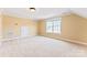 A charming bedroom with neutral carpet, paint, white trim, a window, and a small door at 108 Forrester Ave, Belmont, NC 28012