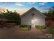 Detached garage with white siding and a landscaped courtyard with seating and flowers at dusk at 108 Forrester Ave, Belmont, NC 28012