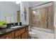 Bathroom featuring wooden cabinets, granite countertops, and tiled shower at 11911 Ridgeway Park Dr, Charlotte, NC 28277
