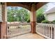 Inviting front porch featuring brick columns and white railing overlooking the landscaped front yard at 11911 Ridgeway Park Dr, Charlotte, NC 28277