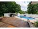 Backyard featuring an outdoor kitchen, pool and deck, all surrounded by trees and a white fence at 1197 Fincher Rd, Fort Lawn, SC 29714