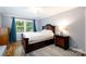 A bedroom featuring light grey walls, wood floors, a window with blue curtains, and dark wood furniture at 1197 Fincher Rd, Fort Lawn, SC 29714