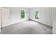 Bright bedroom with neutral carpet, two sunlit windows, and a closet door at 1224 Bethlehem Rd, Kings Mountain, NC 28086