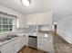 Well-lit kitchen with white cabinets, stainless steel dishwasher and view to backyard at 1224 Bethlehem Rd, Kings Mountain, NC 28086