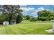 Lush green backyard with storage buildings, beautiful landscaping, and mature trees at 1266 18Th Ne St, Hickory, NC 28601