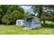 Storage shed with painted siding and double doors set among trees and green lawn at 1266 18Th Ne St, Hickory, NC 28601