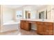 Bright bathroom featuring double vanity, large mirror, and soaking tub by window, promoting relaxation at 13305 Mallard Landing Rd, Charlotte, NC 28278