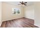 This cozy bedroom features a ceiling fan, large window, and wood floors at 13305 Mallard Landing Rd, Charlotte, NC 28278