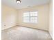 Bright bedroom with a neutral color scheme, plush carpeting, and a large window providing natural light at 13305 Mallard Landing Rd, Charlotte, NC 28278