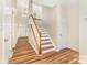 Hallway featuring hardwood floors, a staircase, and natural light, creating a welcoming atmosphere at 13305 Mallard Landing Rd, Charlotte, NC 28278