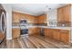 Well-lit kitchen featuring wooden cabinetry, modern appliances, and hardwood flooring at 13305 Mallard Landing Rd, Charlotte, NC 28278