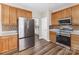 Modern kitchen featuring stainless steel appliances, wooden cabinetry, and hardwood floors at 13305 Mallard Landing Rd, Charlotte, NC 28278