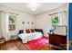 Bright bedroom with hardwood floors, a daybed, and desk area, illuminated by natural light from two windows at 1344 Shannonhouse Dr, Charlotte, NC 28215