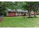 Charming brick home with a well-manicured lawn and mature trees at 1344 Shannonhouse Dr, Charlotte, NC 28215