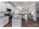 Open-concept kitchen boasts stainless appliances, granite counters, and stylish finishes at 148 Kerri Dawn Ln, Locust, NC 28097