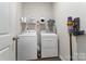 Functional laundry room featuring modern washer, dryer, shelving, and cleaning supplies at 148 Kerri Dawn Ln, Locust, NC 28097