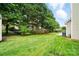 View of backyard with a lush green lawn, mature trees, and a fence at 1522 Napa Nw St, Concord, NC 28027