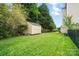 Spacious backyard features a lush lawn, mature trees, and a convenient storage shed at 1522 Napa Nw St, Concord, NC 28027