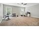 Spacious bedroom featuring a ceiling fan, two windows, and home office/gym setup at 1522 Napa Nw St, Concord, NC 28027