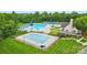 Aerial view of the community pools, a waterslide, and a clubhouse with a well-maintained lawn at 1522 Napa Nw St, Concord, NC 28027
