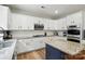 Open kitchen area with white cabinets, stainless appliances, and a center island with countertop seating at 1522 Napa Nw St, Concord, NC 28027