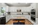 A kitchen island offers seating and workspace in this renovated kitchen with white cabinets and black hardware at 1522 Napa Nw St, Concord, NC 28027