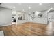 Bright, open-concept living space with hardwood floors and access to the kitchen and staircase at 1522 Napa Nw St, Concord, NC 28027