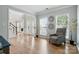 Inviting living room with hardwood floors, a comfortable armchair, and abundant natural light through large windows at 1522 Napa Nw St, Concord, NC 28027