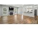 Open living room featuring a stone fireplace, large windows, and hardwood floors at 1522 Napa Nw St, Concord, NC 28027