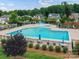 Large community pool with lounge chairs and umbrellas, surrounded by lush greenery and neighborhood homes at 200 Sweet Briar Dr, Fort Mill, SC 29707