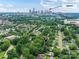 Aerial view of the neighborhood with mature trees and the house marked with a red pin, uptown in the distance at 2017 Brewton Dr, Charlotte, NC 28206