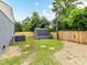 Landscaped backyard with a wooden privacy fence, a storage shed, and mature trees at 2017 Brewton Dr, Charlotte, NC 28206