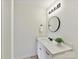 Clean bathroom featuring a vanity with white countertops, round mirror, modern lighting, and updated fixtures at 2017 Brewton Dr, Charlotte, NC 28206