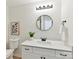 Bright bathroom featuring a white vanity with black hardware, round mirror, and stylish decor at 2017 Brewton Dr, Charlotte, NC 28206