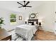 A well-lit bedroom with a ceiling fan, large window, and neatly styled bed with coordinated decor at 2017 Brewton Dr, Charlotte, NC 28206