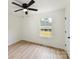 A simple bedroom with a ceiling fan, a window, and wood-look flooring at 2017 Brewton Dr, Charlotte, NC 28206