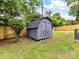 Close up of grey storage shed with grey double doors and a shingled roof at 2017 Brewton Dr, Charlotte, NC 28206